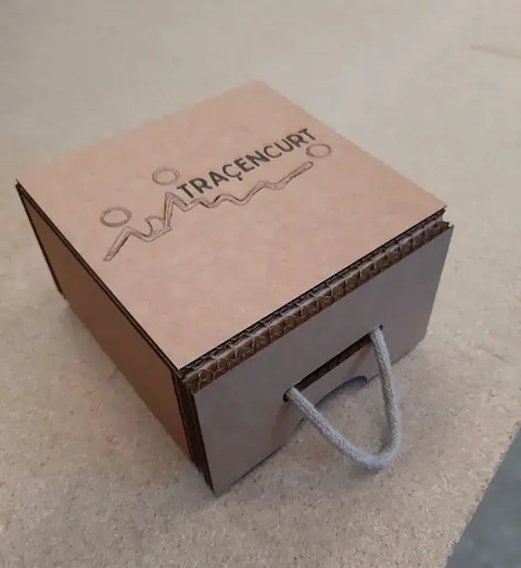 Estuche de cartón con tapa y asa de cuerda, grabado por láser